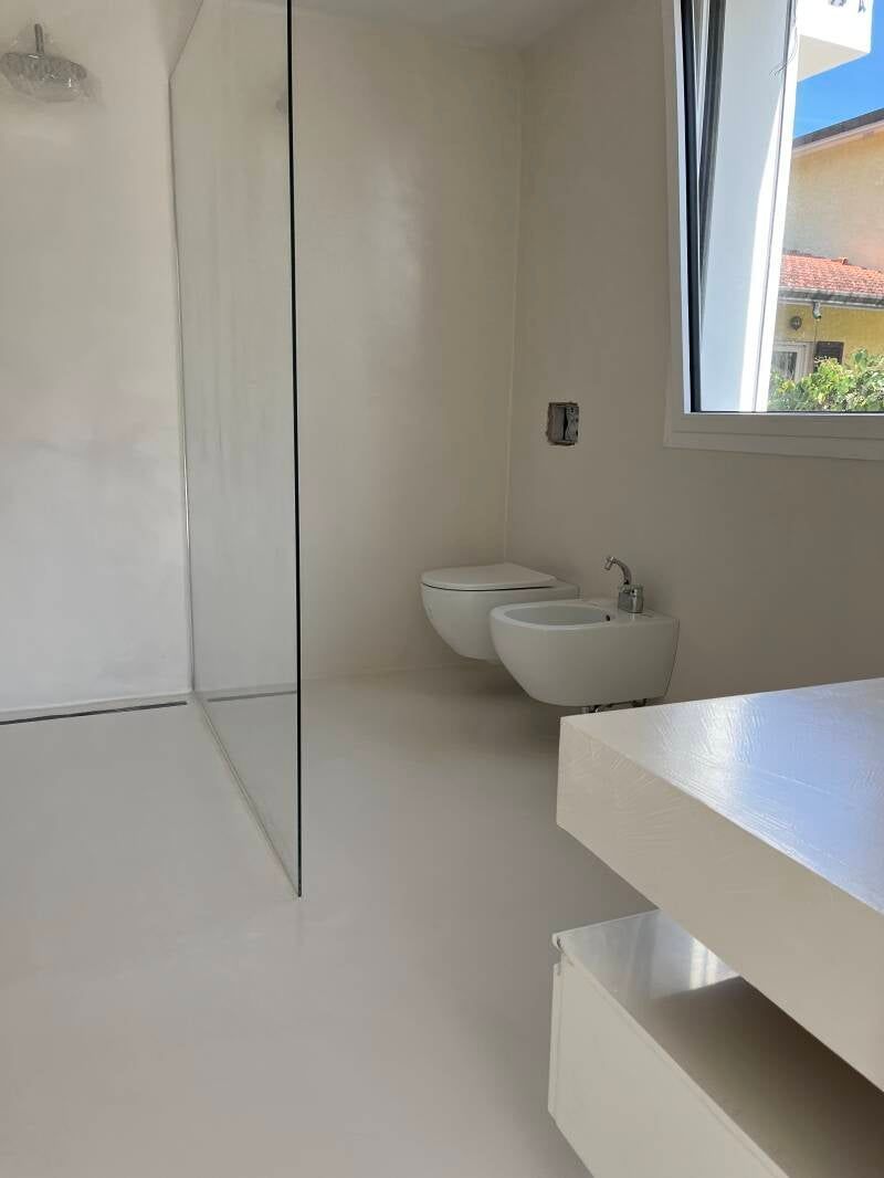 Bagno bianco con doccia, WC e bidet. Finestra con vista sull'esterno.