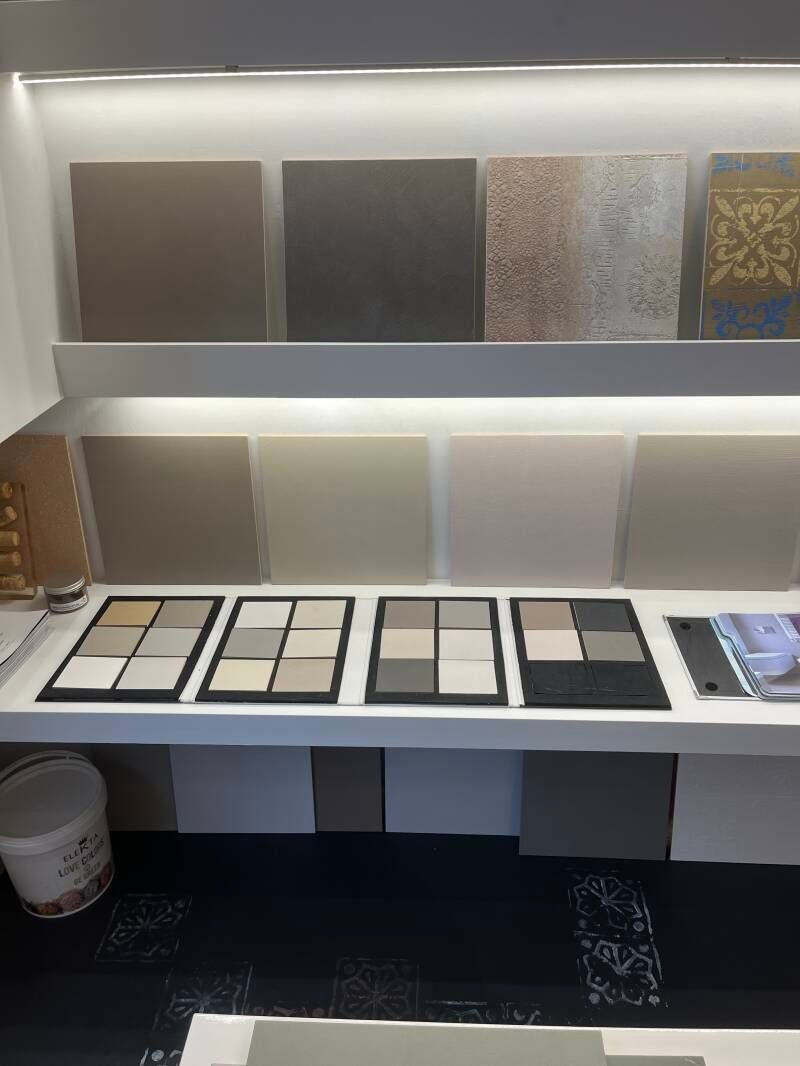 Esposizione di varie piastrelle in colori neutri, disposte su scaffali.