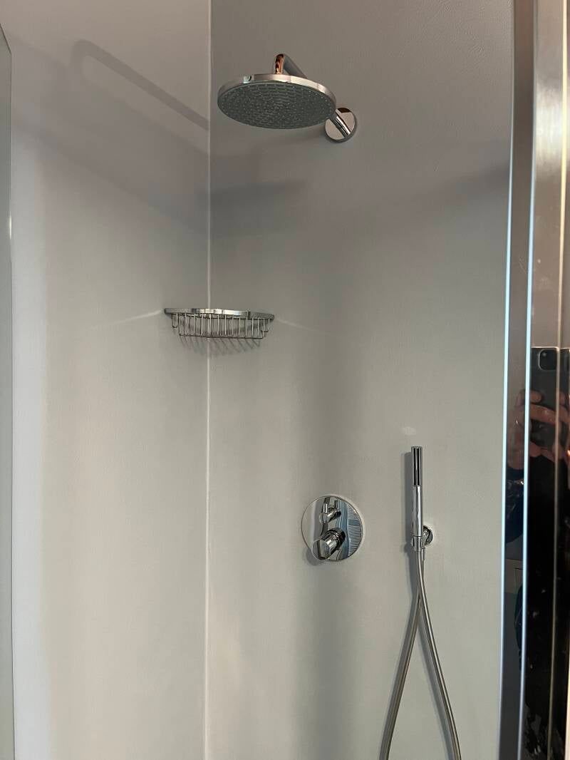 Box doccia con soffione a pioggia, portasapone e doccetta.