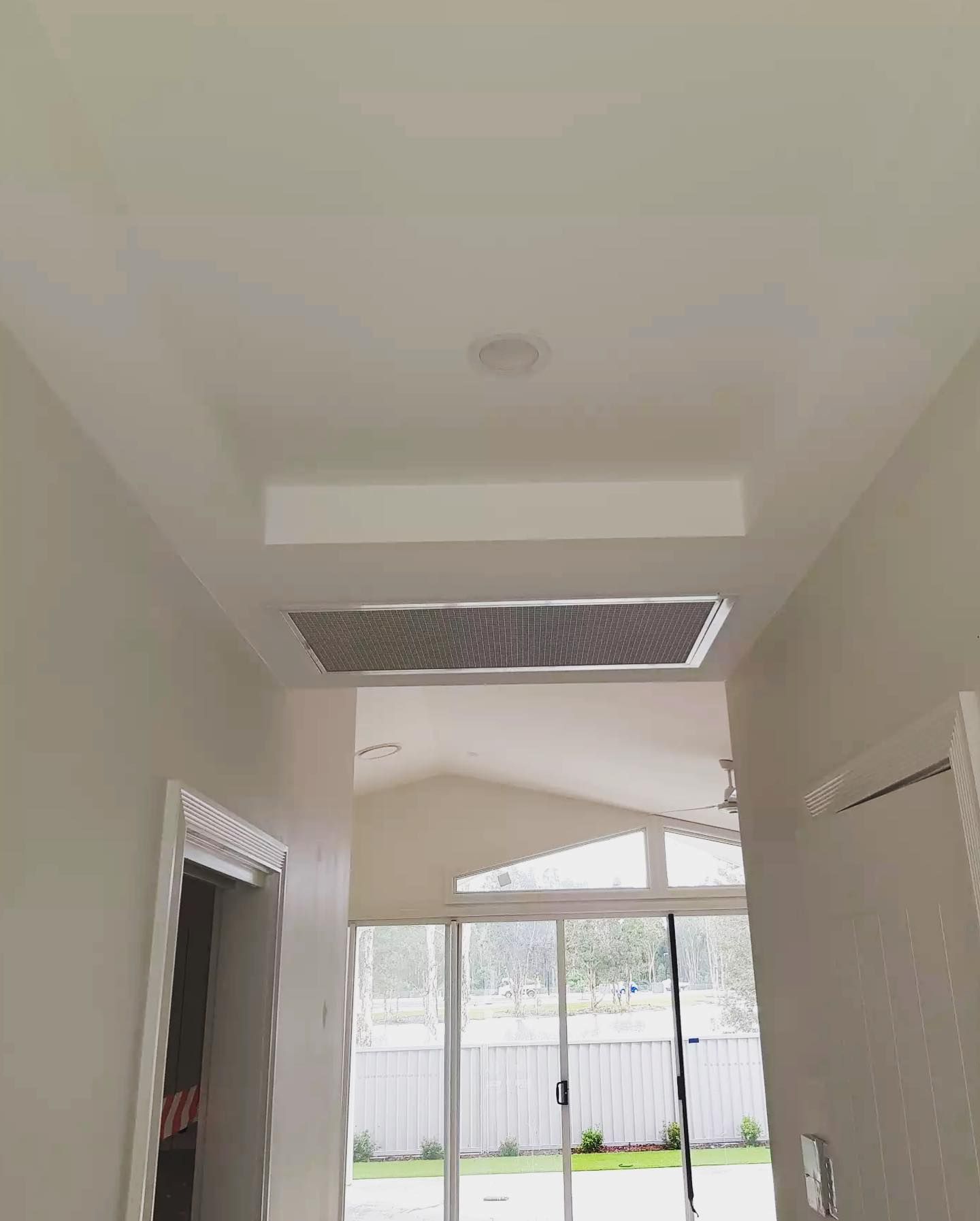 A Hallway With a Ceiling Fan and a Sliding Glass Door — Atmosphere Air Conditioning & Refrigeration In Fern Bay, NSW