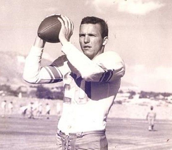 A black and white photo of a man throwing a football