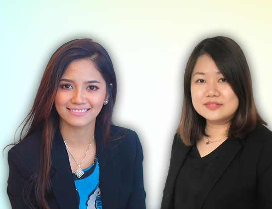 Two smiling women in business attire, against a gradient backdrop.