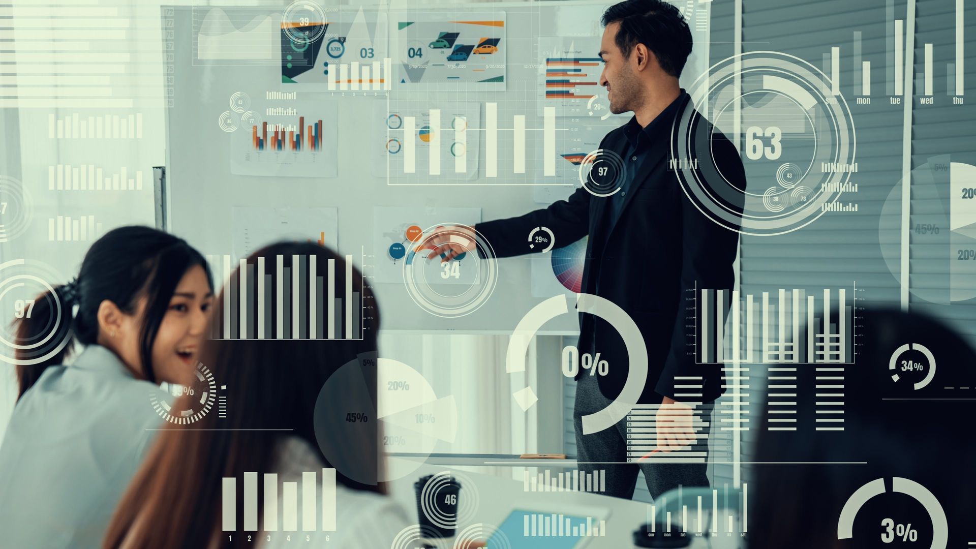 Man presenting data on whiteboard to a team in an office setting.