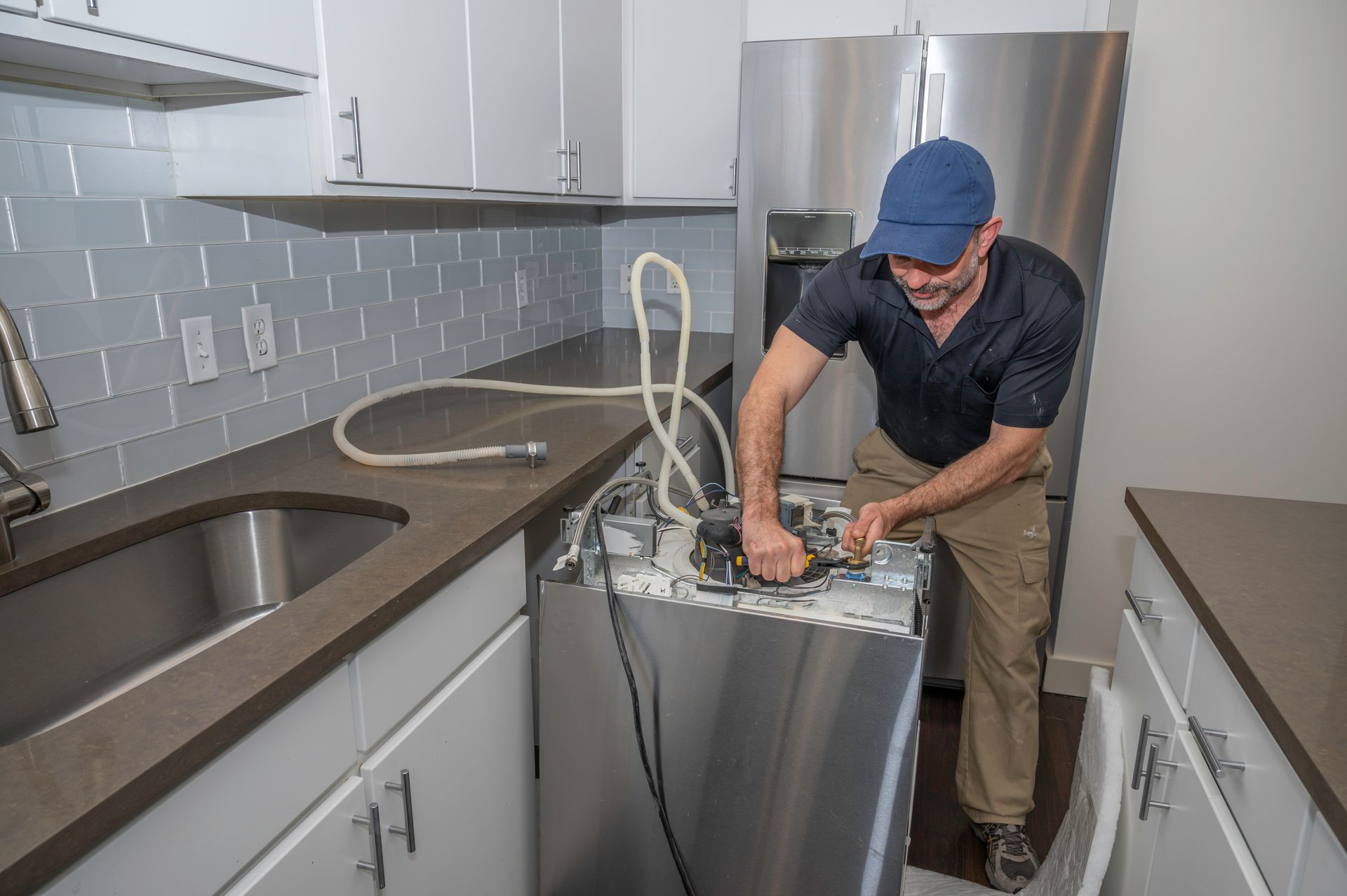 Certified technician working on a residential dishwasher installation.
