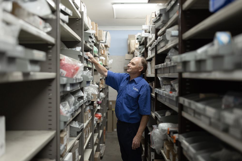 Regional Appliance & Electrical Services staff selecting spare parts from warehouse shelves
