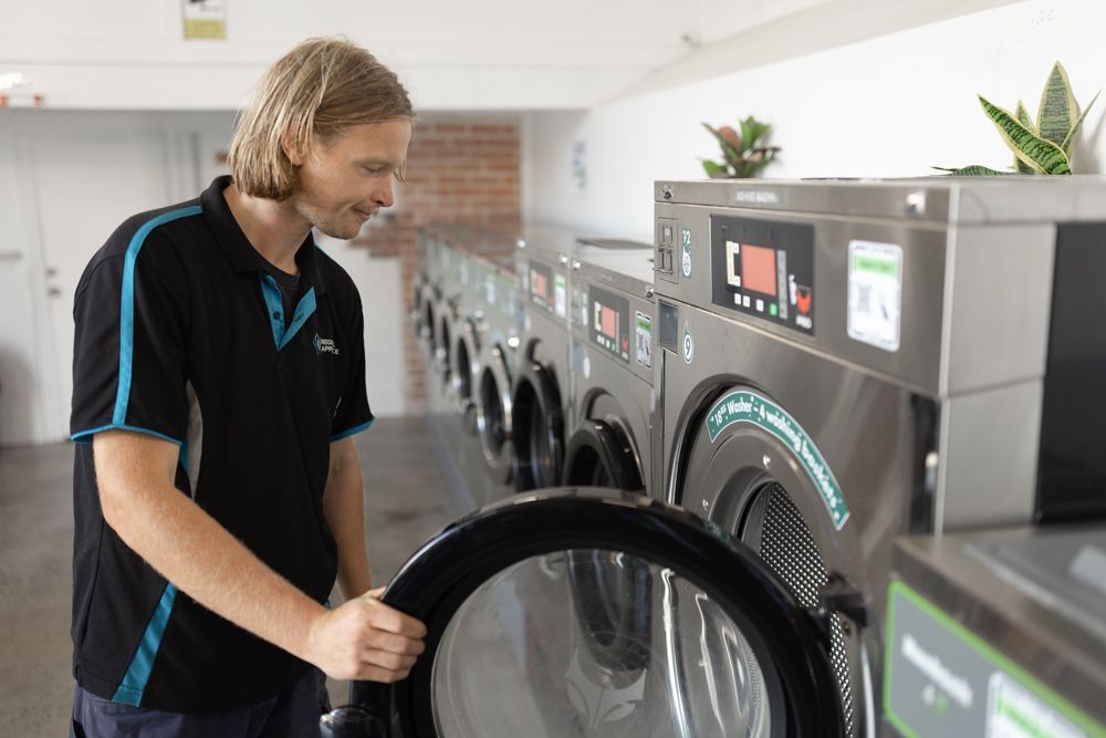 Regional Appliance & Electrical Services technician servicing a commercial washer.