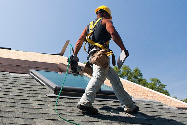 Worker Fixing Roof Tile — Roof Maintenance in Eugene, OR