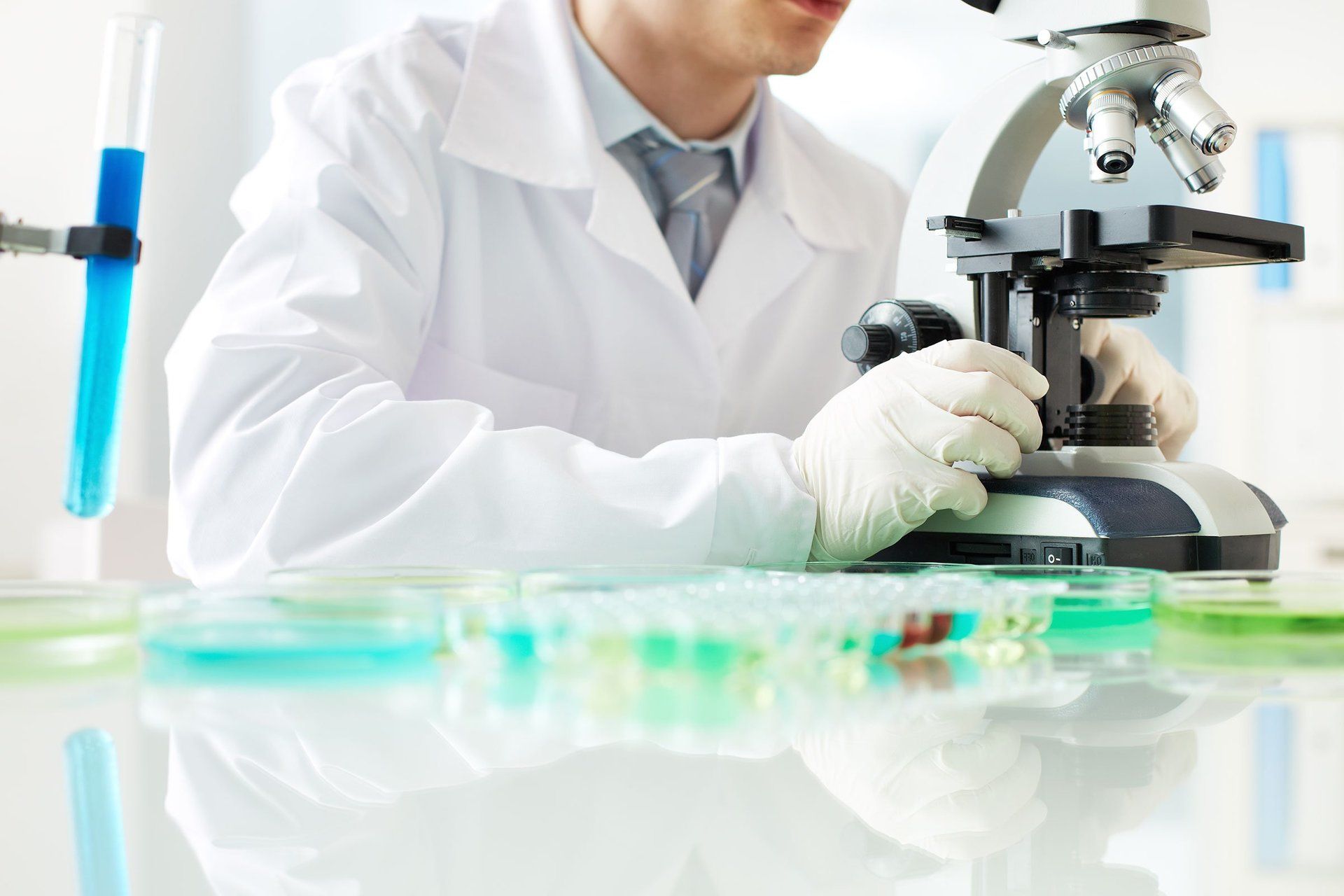 Tecnico di laboratorio con campioni e microscopio