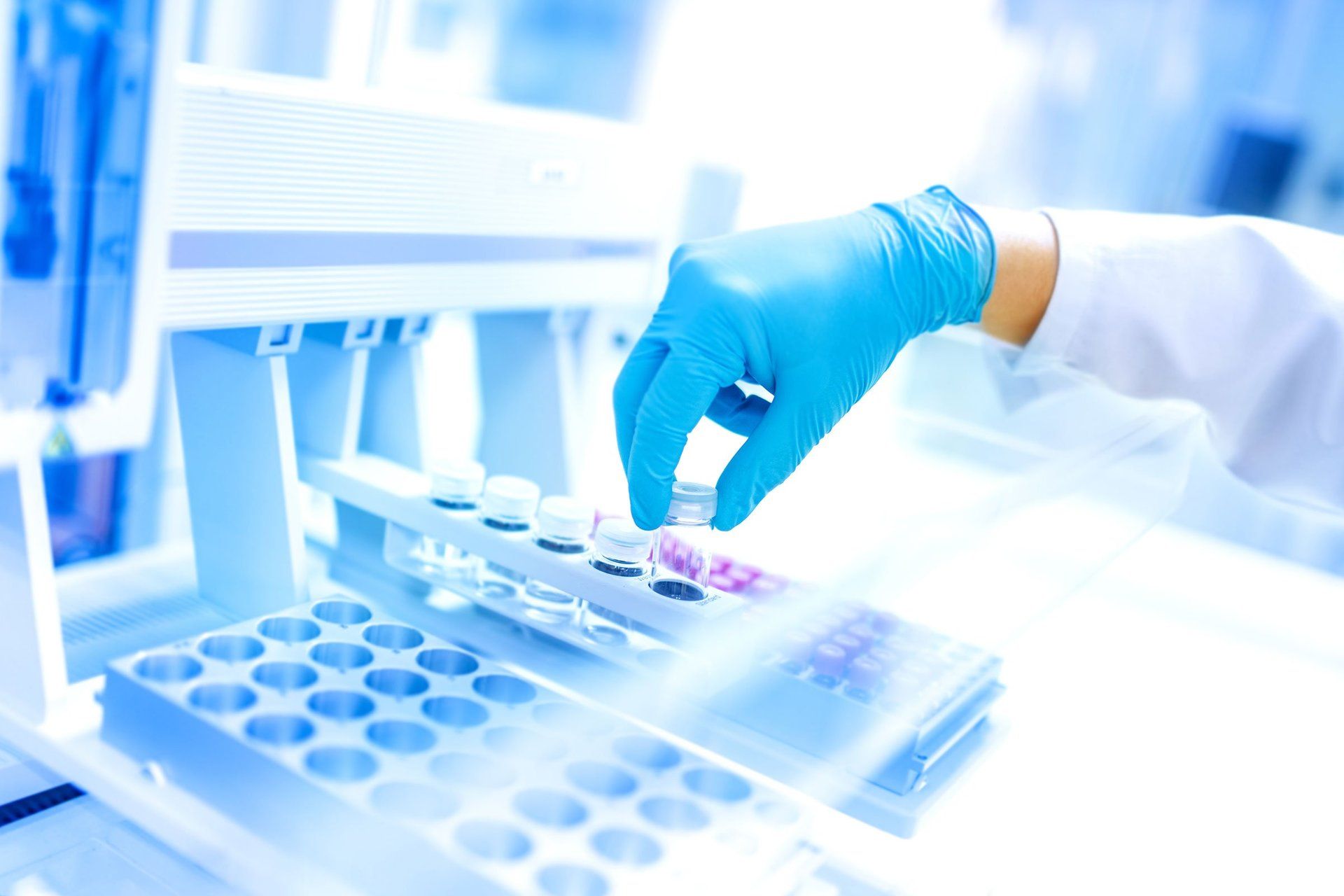 Mano con guanto che sceglie provette in laboratorio