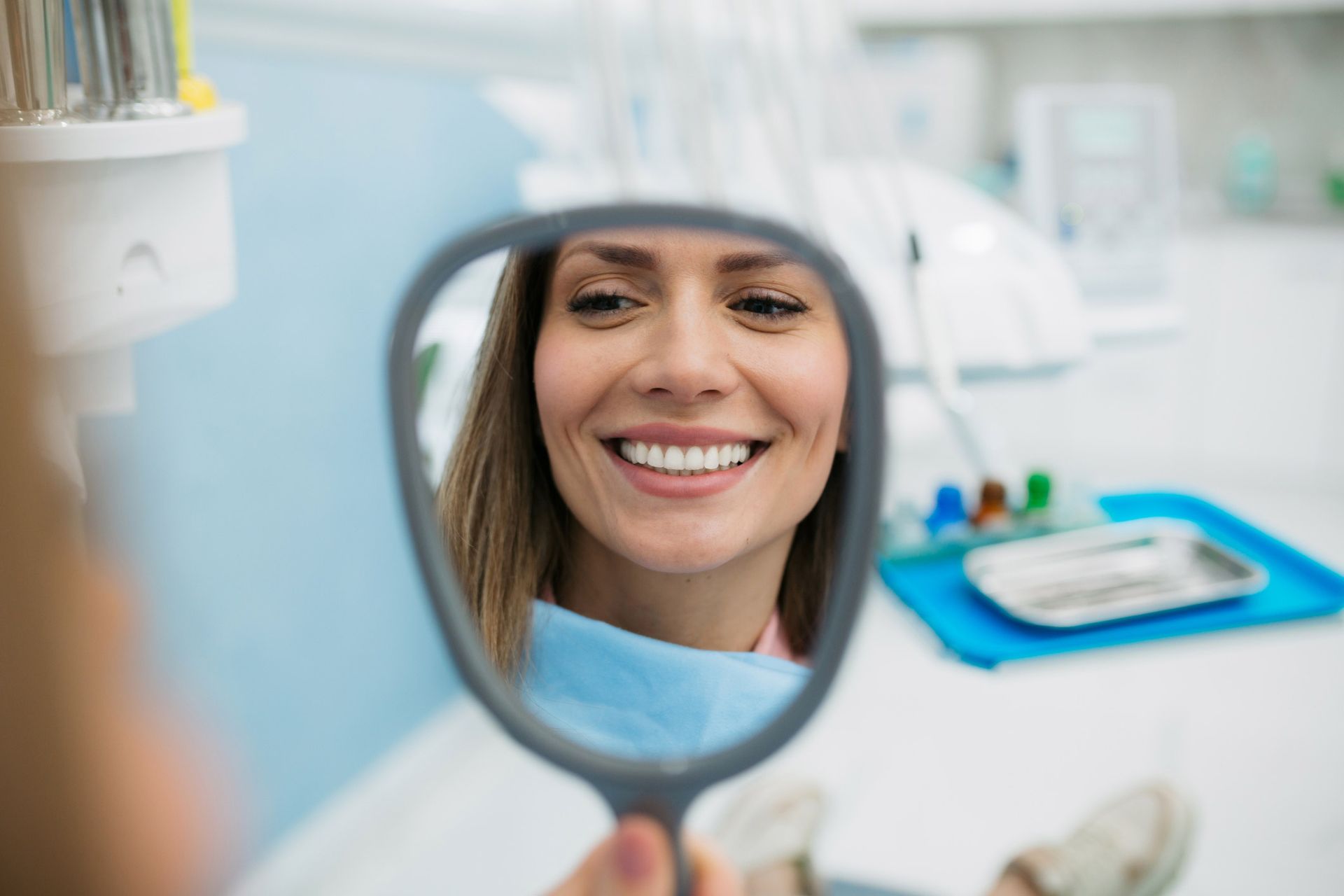 Happy woman smiling at the results of her dental whitening service in Danville, IL, showcasing a bright and radiant white smile.