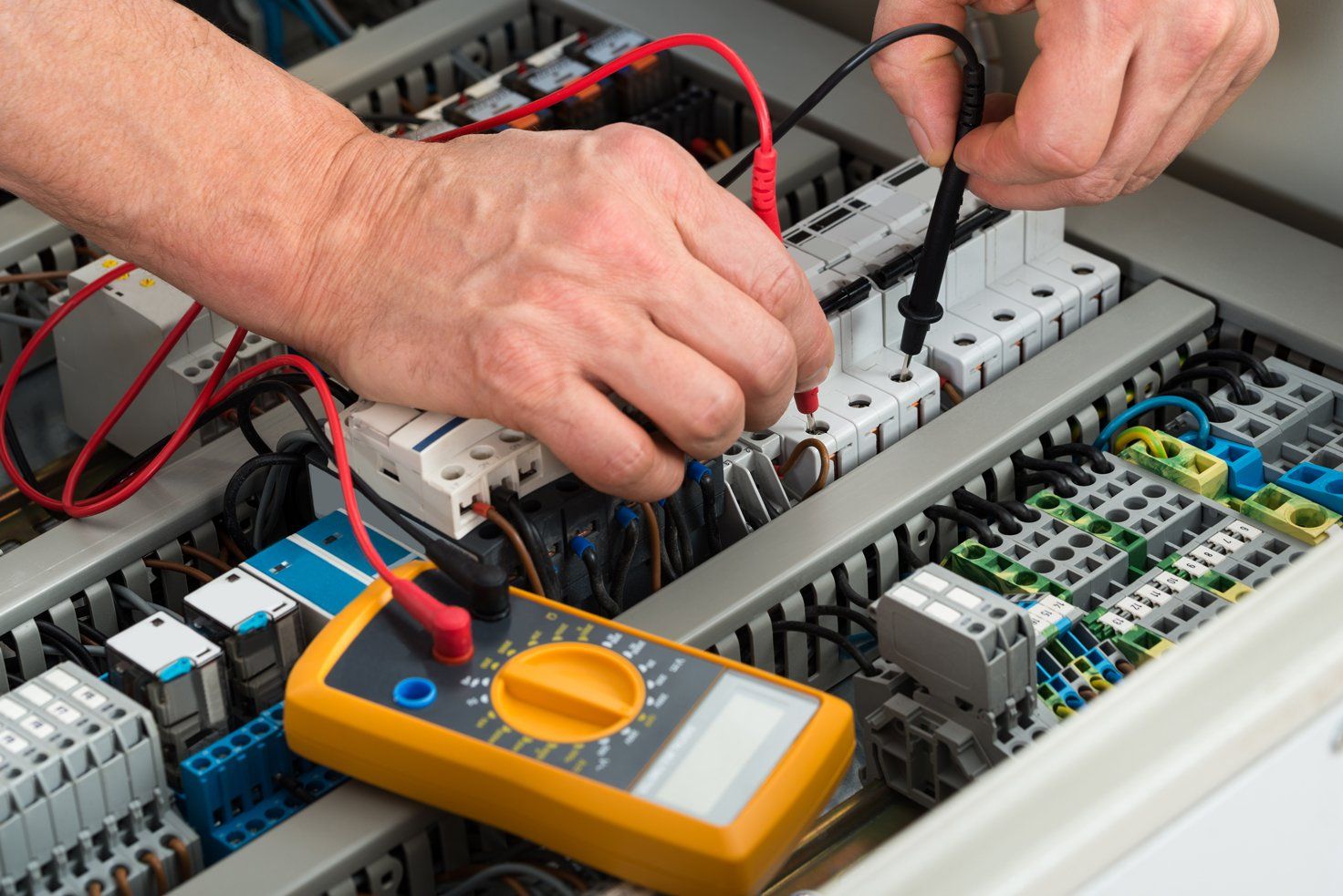 Close-up Of A Male Electrician Checking Fuse With Multimeter