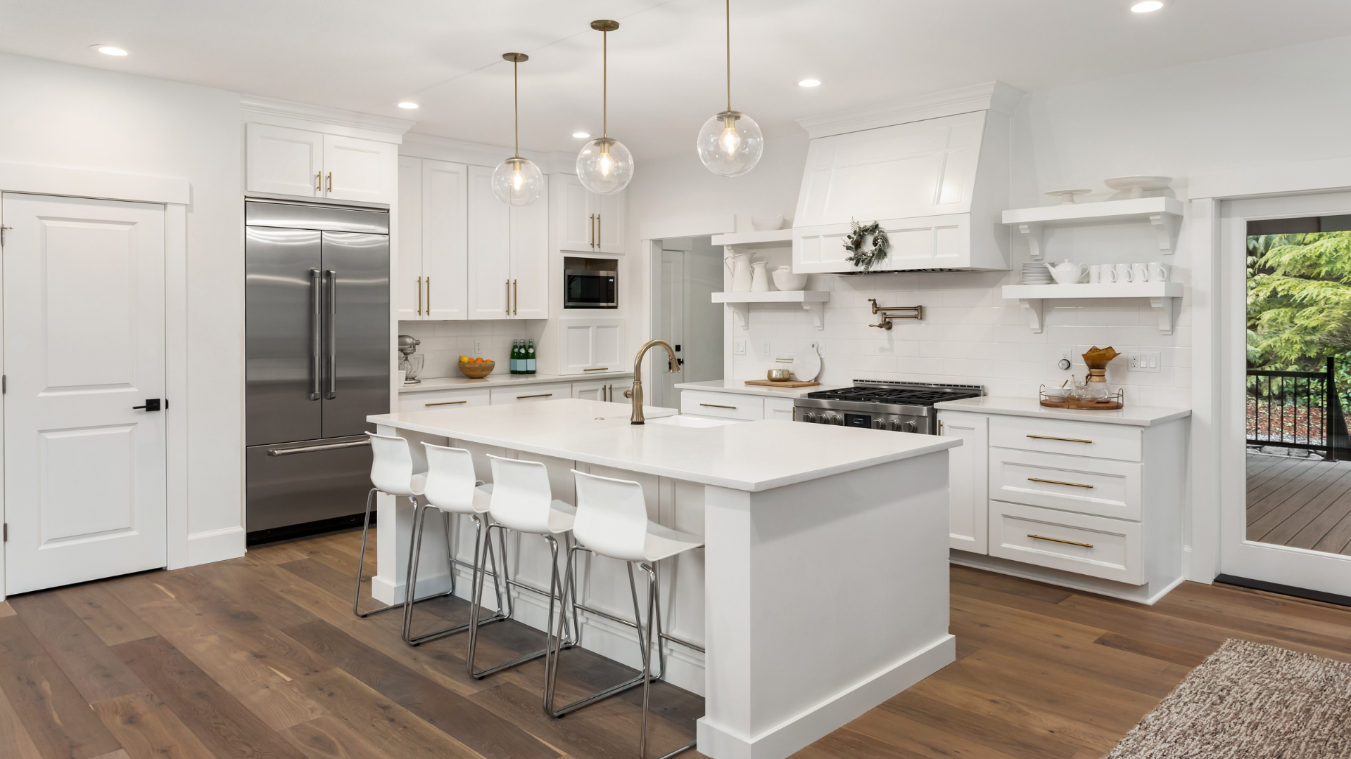 A kitchen with white cabinets , stainless steel appliances , and a large island.