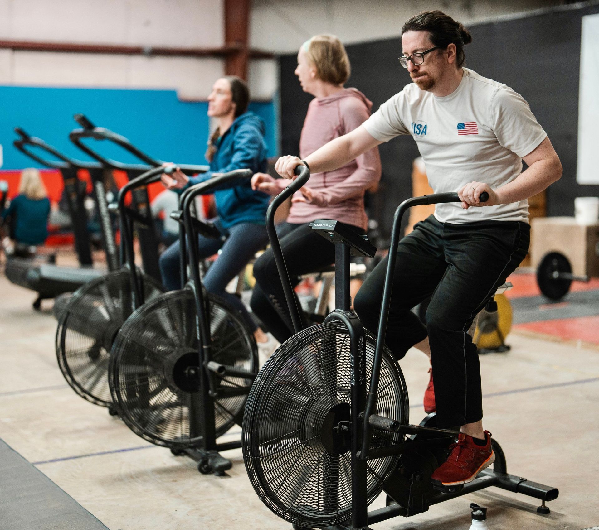 A group of people are riding exercise bikes in a gym.