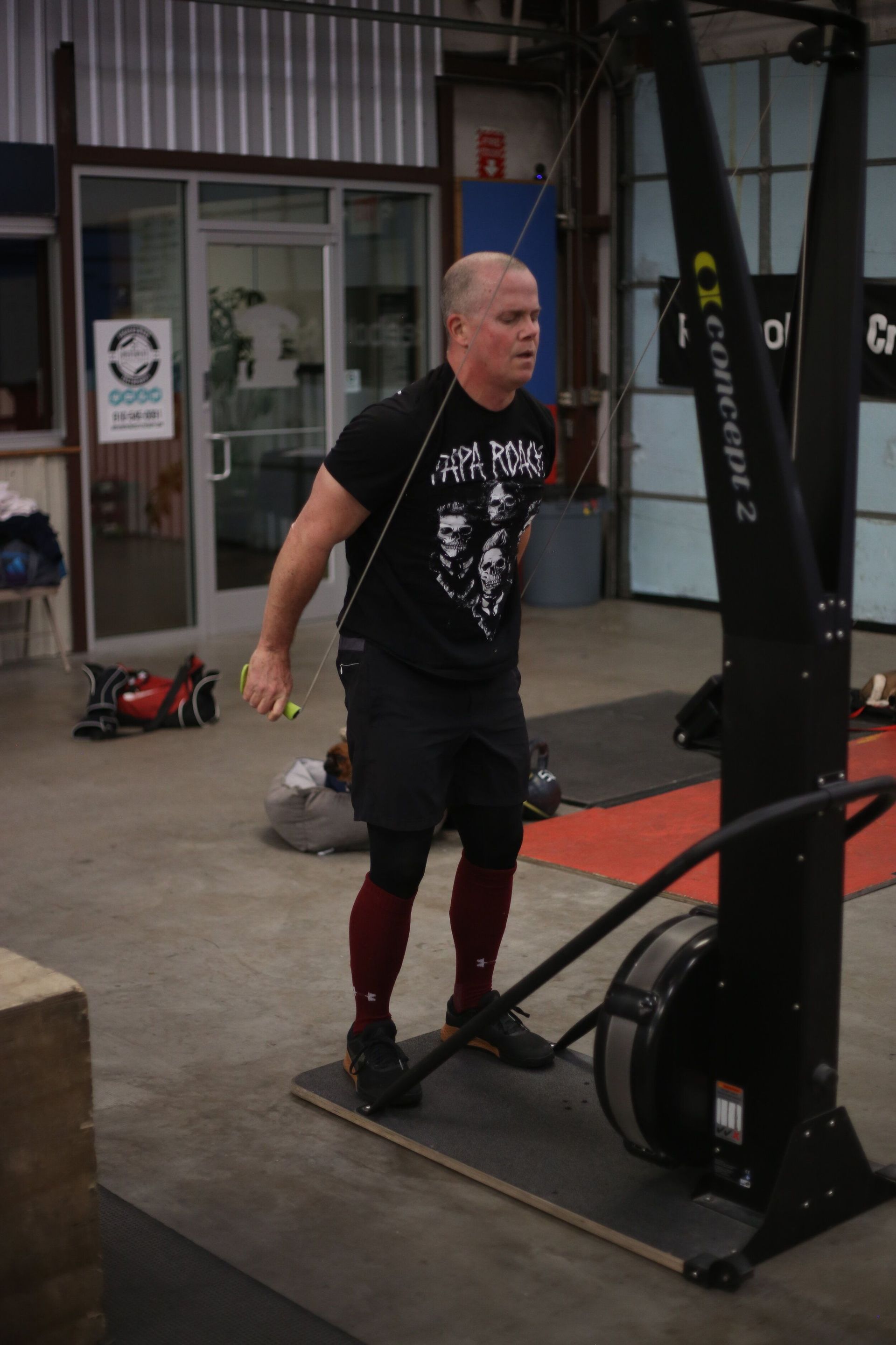 A man is standing in front of a concept 2 machine