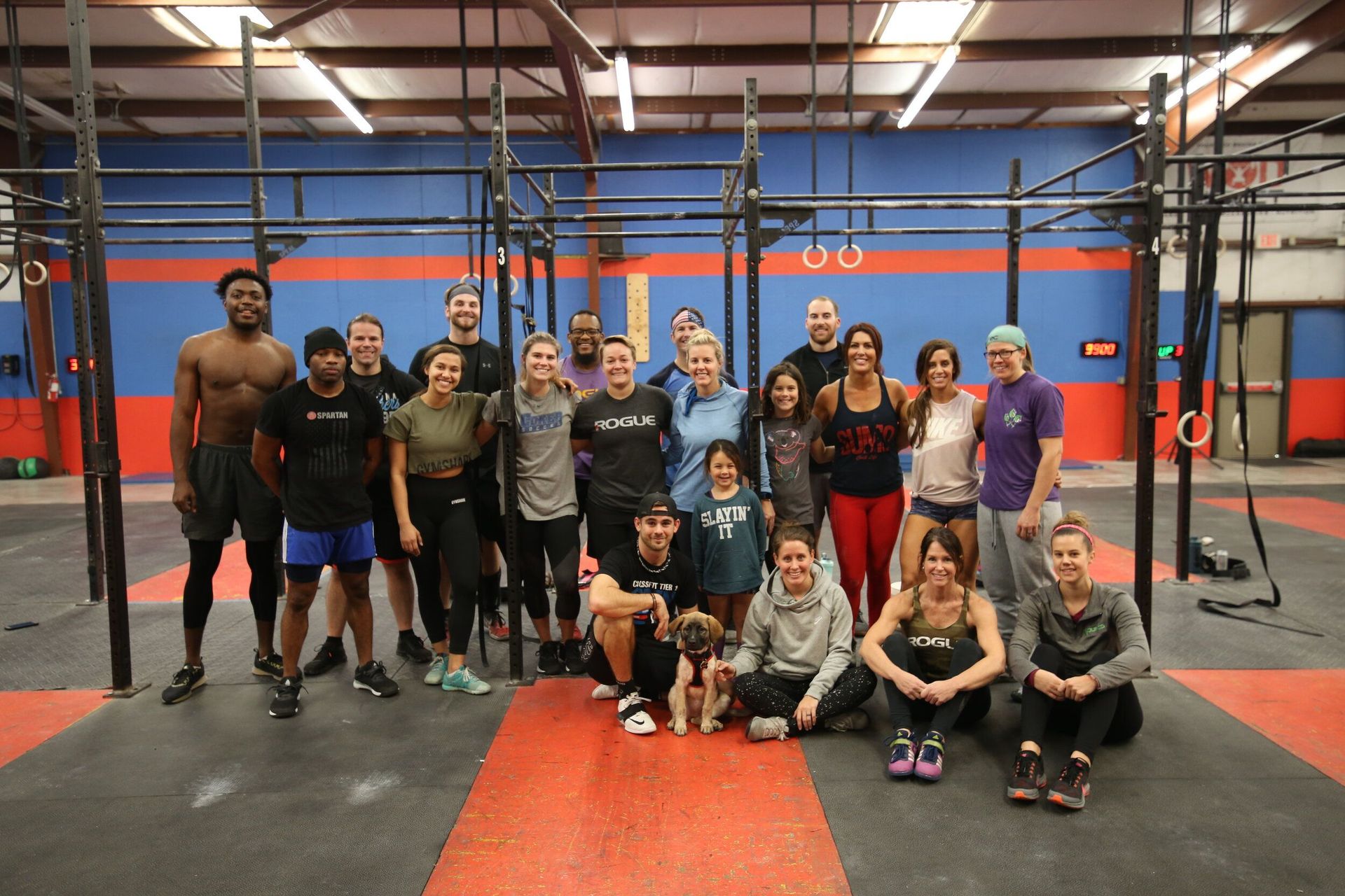 A group of people are posing for a picture in a gym.