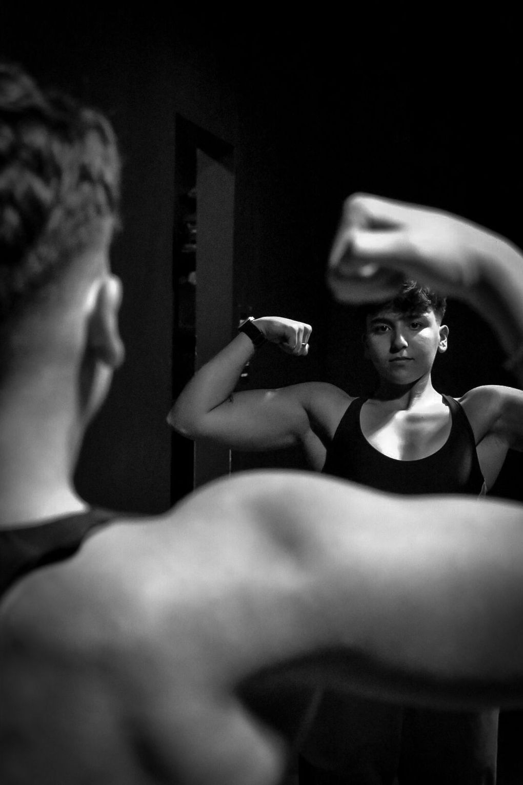 A man is flexing his muscles in front of a mirror.