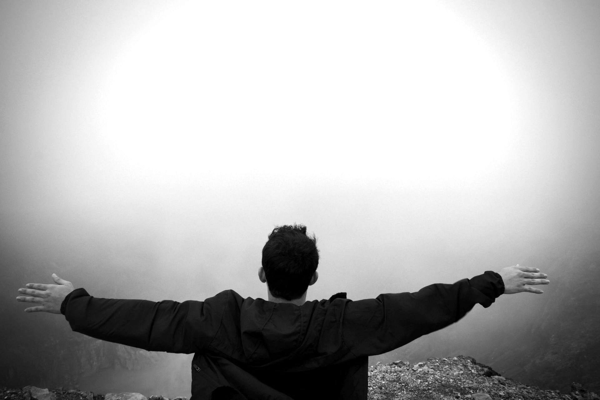 A black and white photo of a man with his arms outstretched