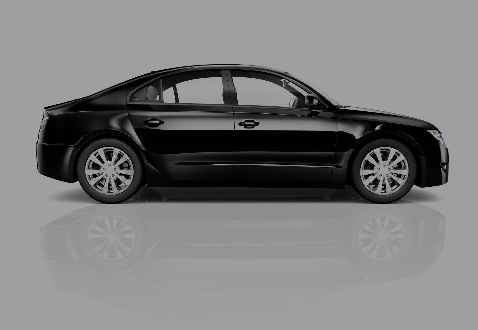 Black sedan car on a reflective surface.