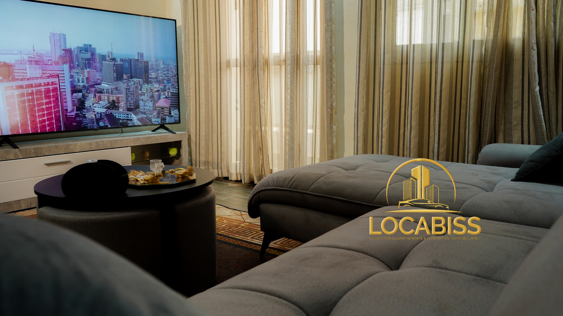 Un salon avec un canapé et une télévision à écran plat.