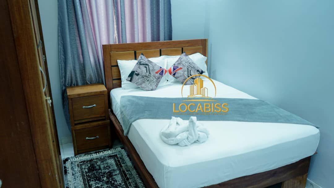 Une chambre avec un lit, une table de nuit et une armoire.