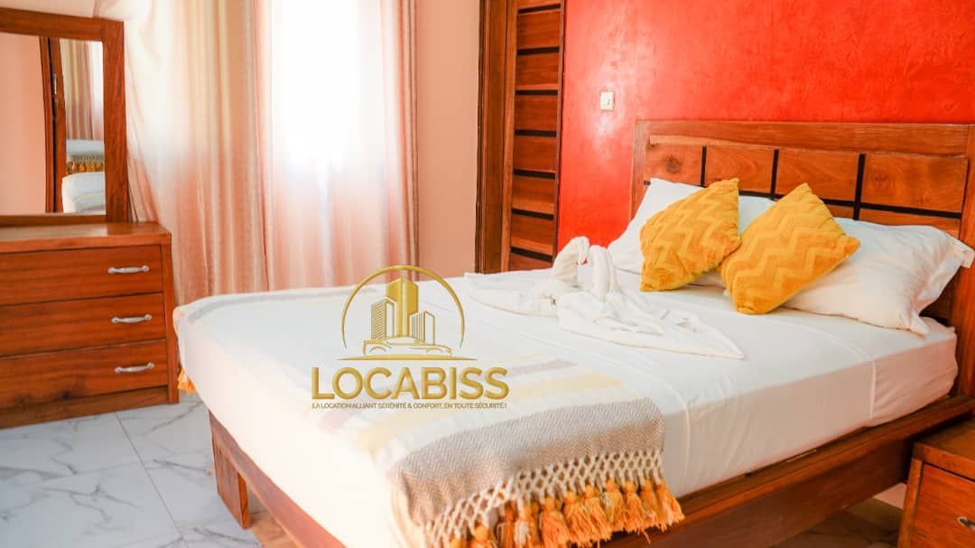 Une chambre avec un lit, une commode, un miroir et une table de nuit.