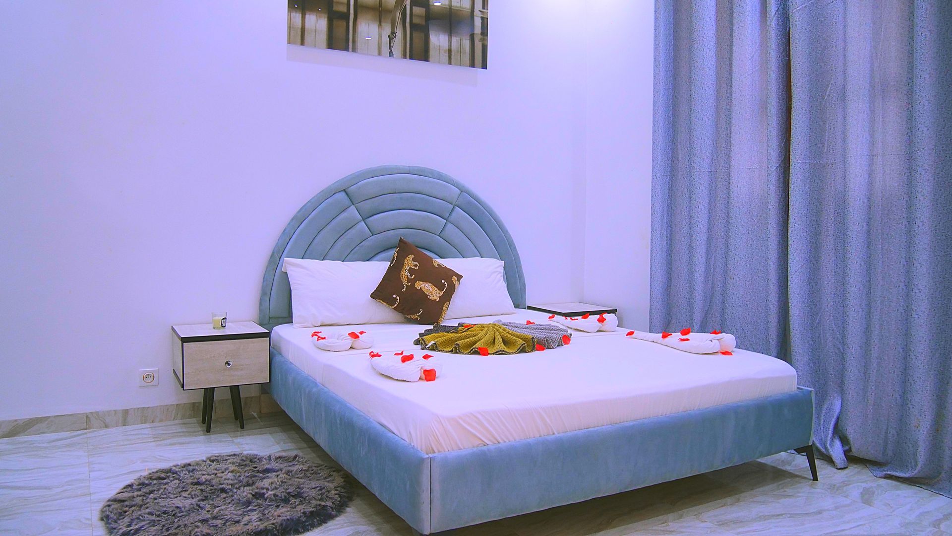 Il y a un lit au milieu de la pièce avec des fleurs dessus.