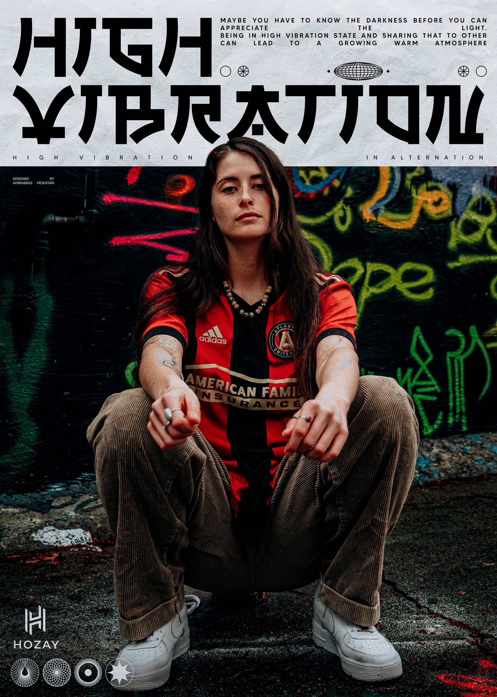 Woman squatting, wearing a soccer jersey and corduroy pants. Graffiti wall background,