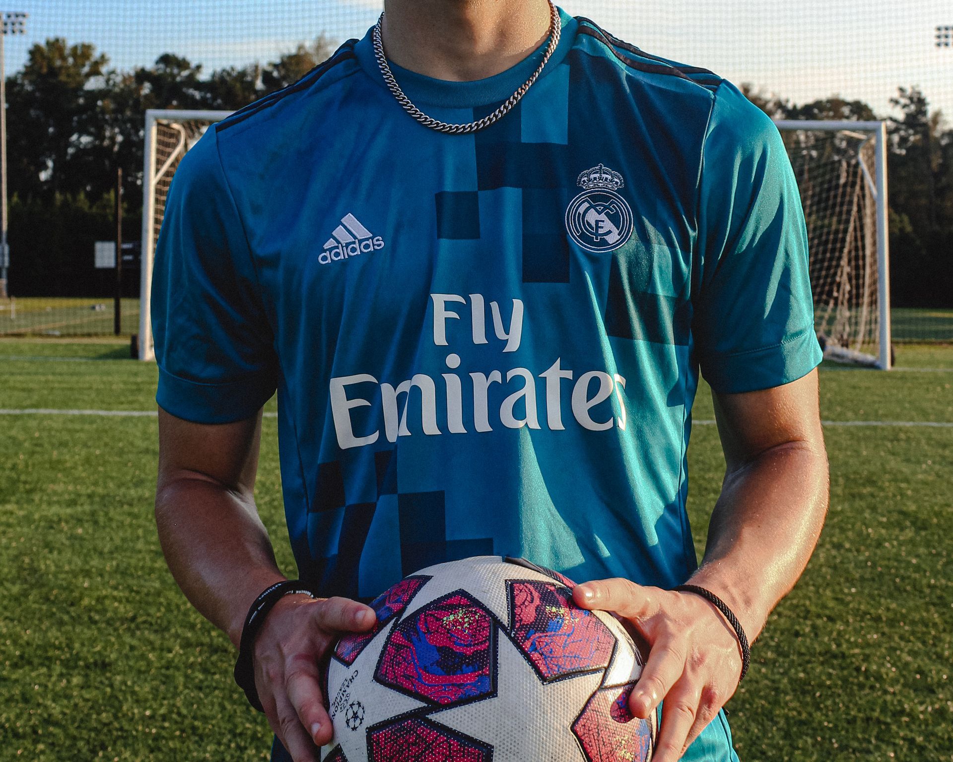 Person holding a soccer ball, wearing a blue jersey with 