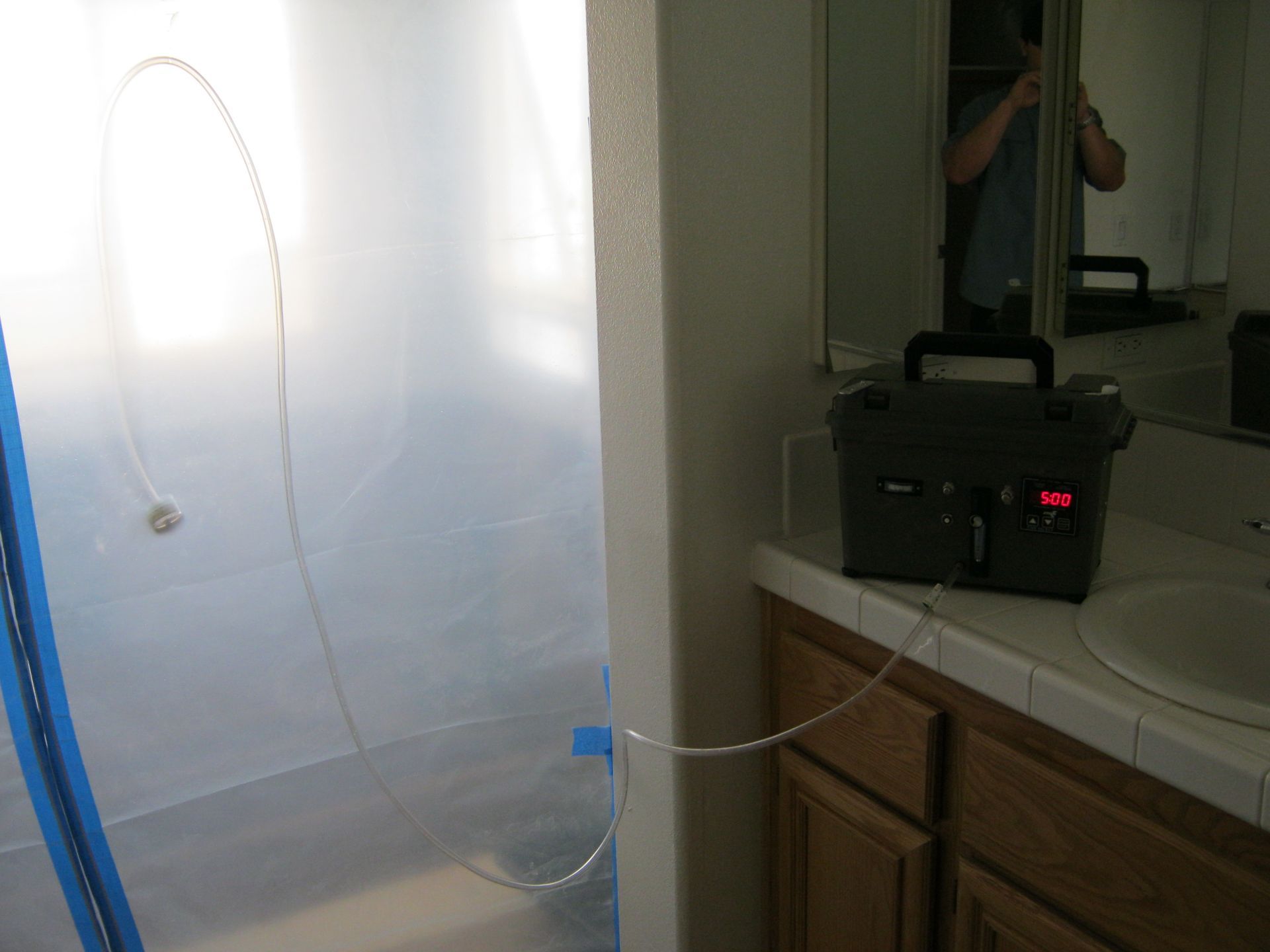 A man is taking a picture of himself in the mirror in a bathroom.