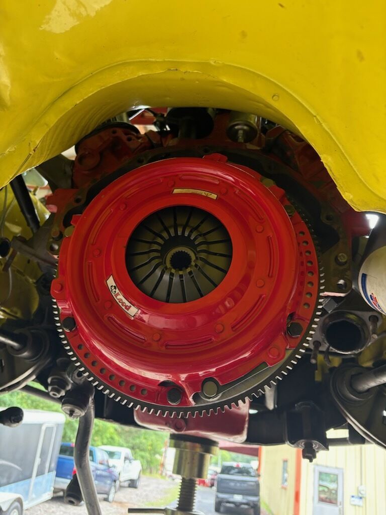 Close-up of a red jet engine inside a yellow aircraft fuselage, with fan blades visible.