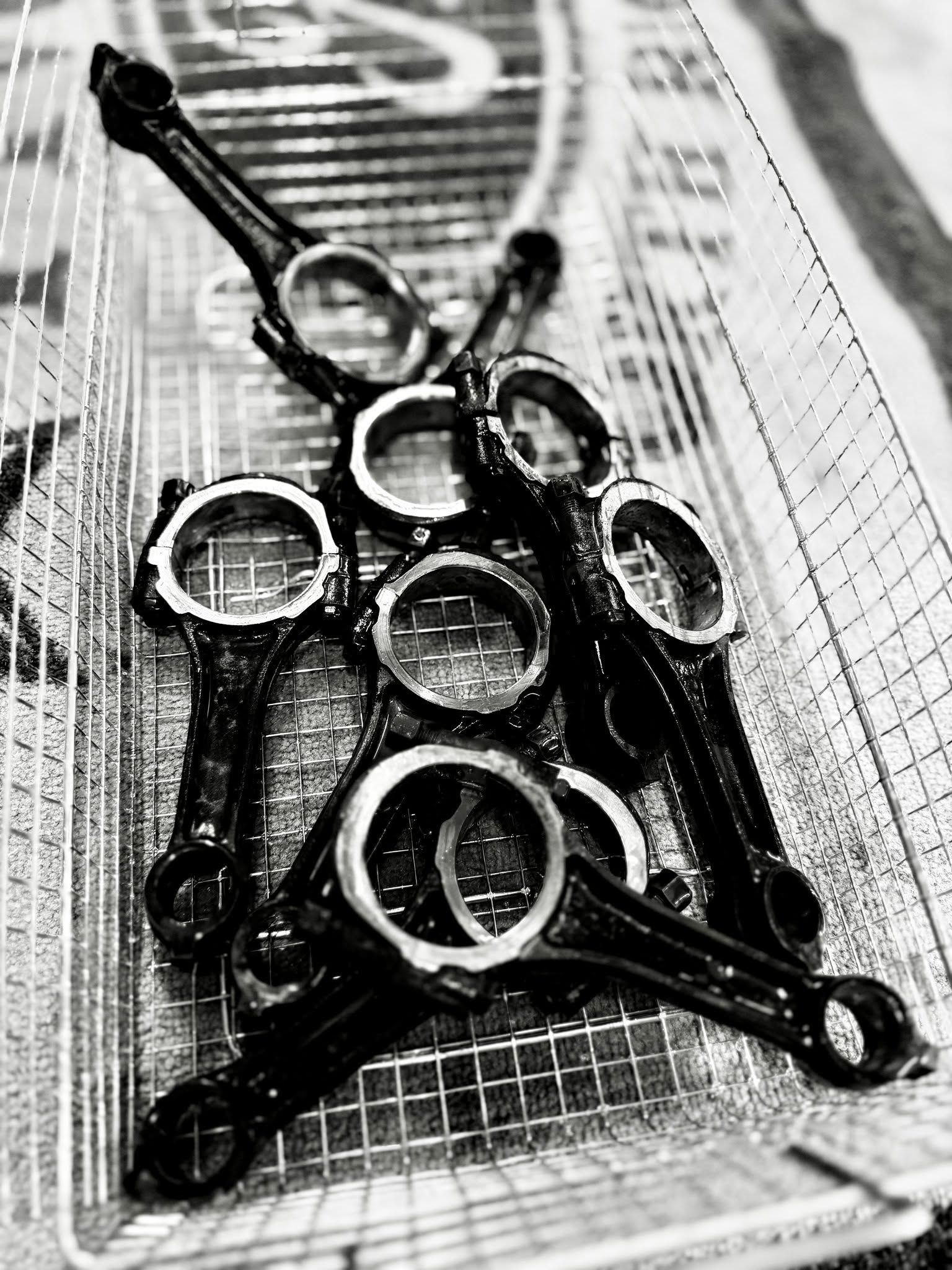 Black-and-white photo of several metal rings and tools stacked in a wire basket