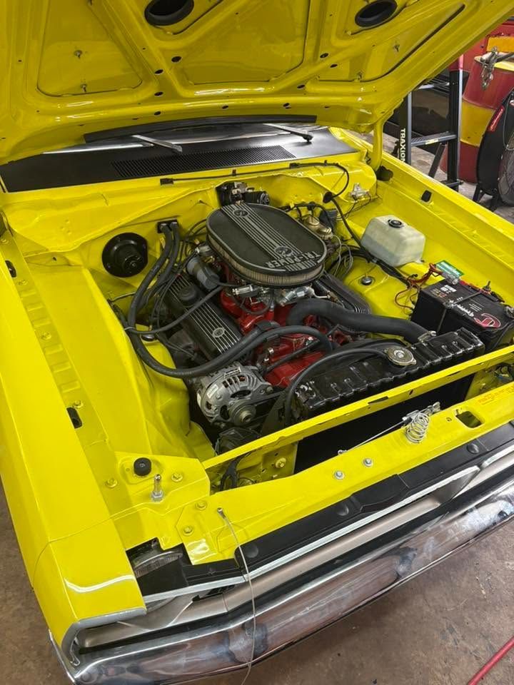 Yellow classic car engine bay with hood open, showing a custom V8 engine.