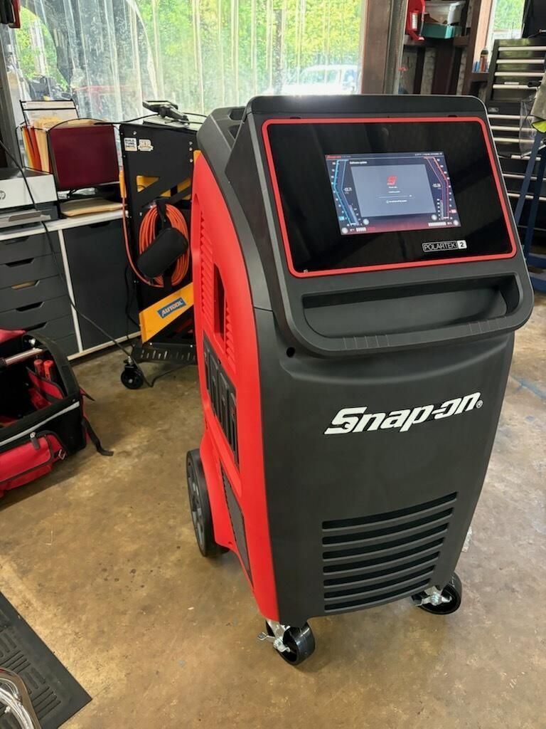 Black and red Snap-on diagnostic scanner cart with touchscreen in a workshop.