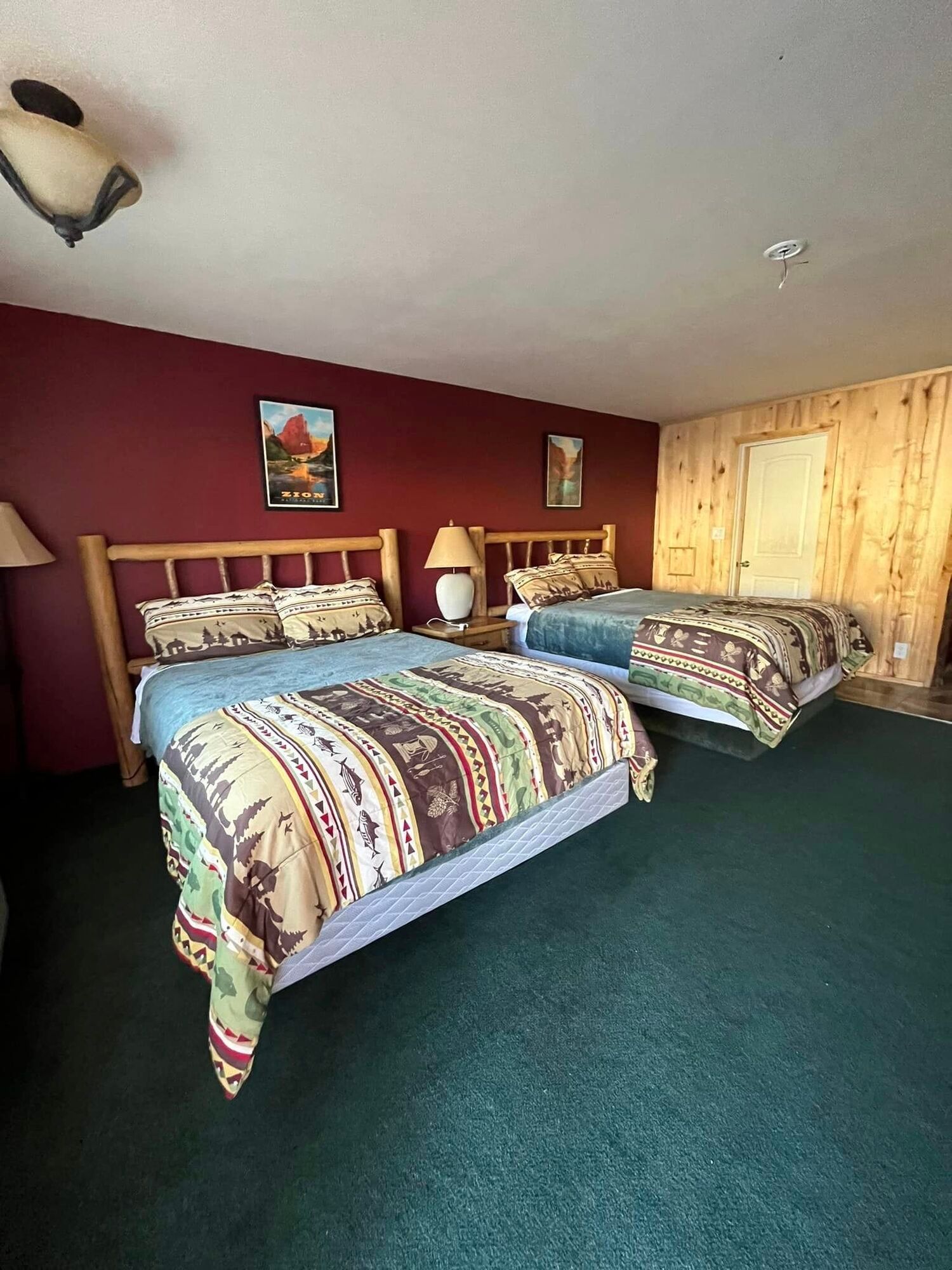 A hotel room with two beds and two lamps.