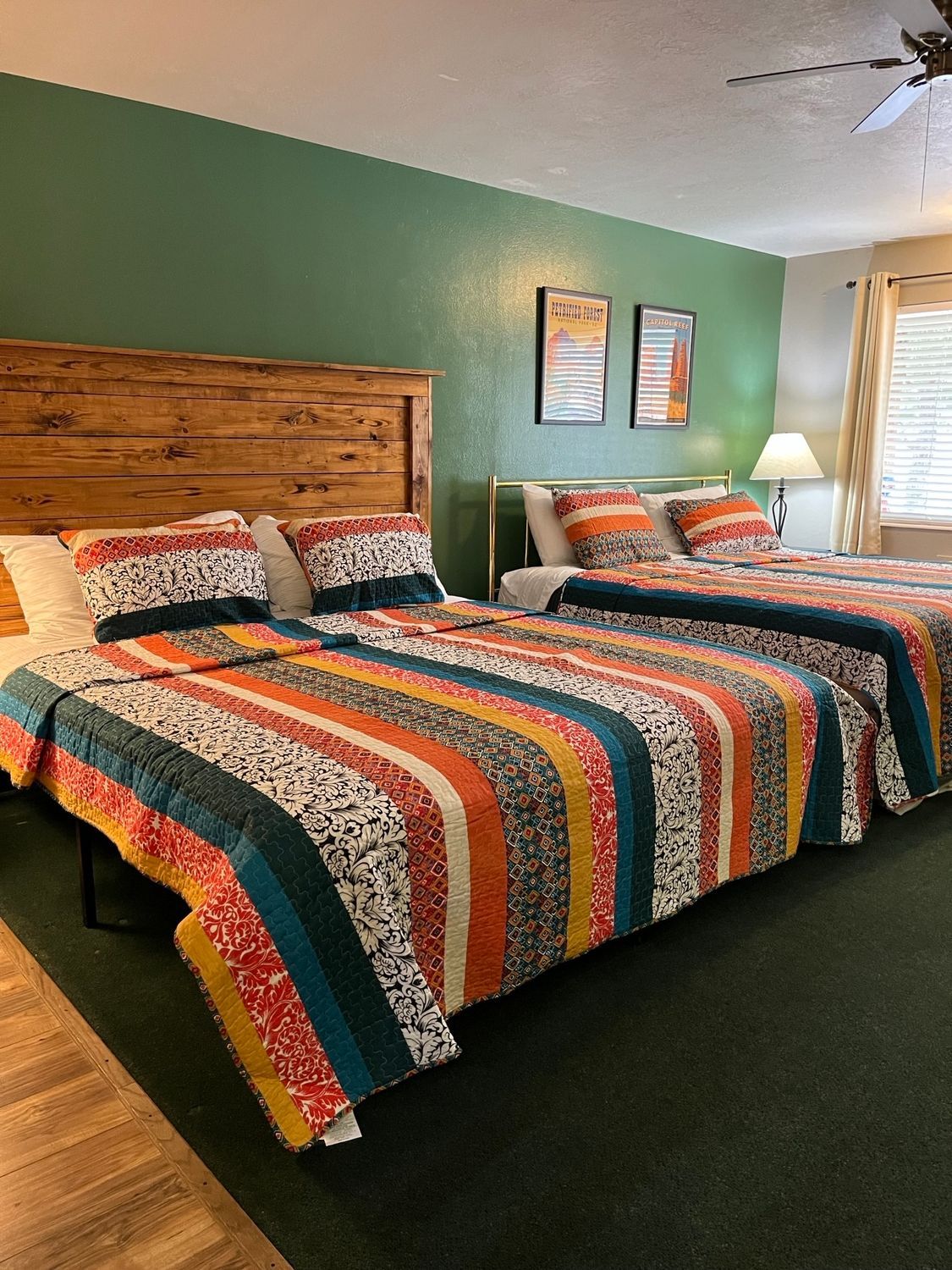 A hotel room with two beds and a ceiling fan.