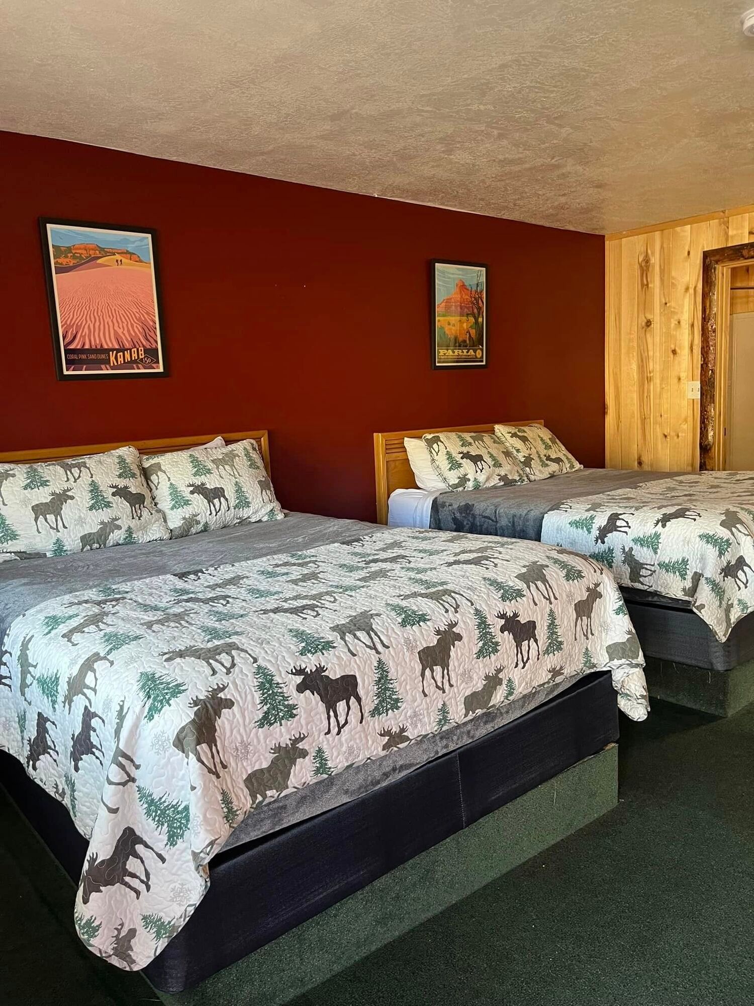 A hotel room with two beds and two pictures on the wall.