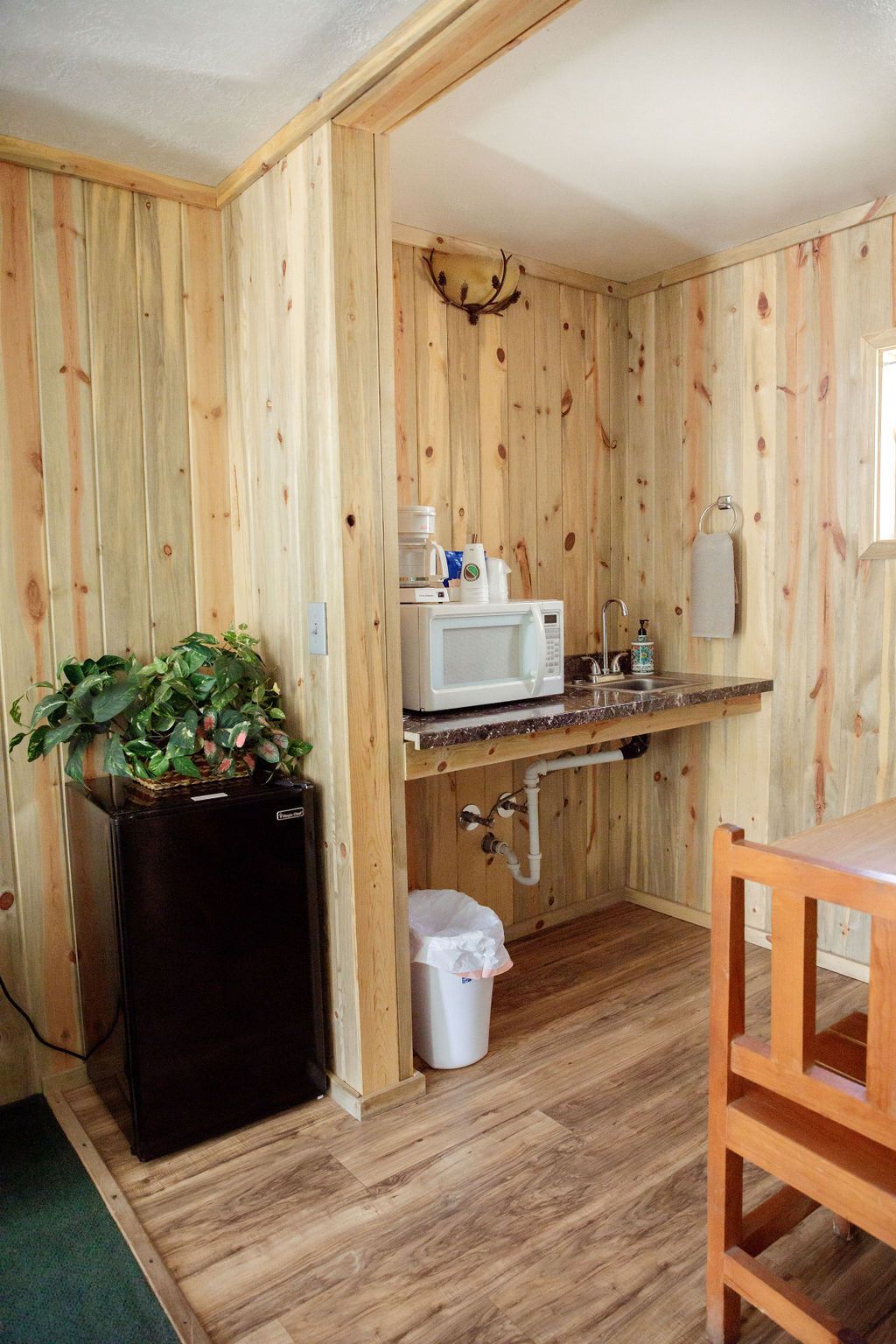 A small kitchen with a sink , microwave , and refrigerator.