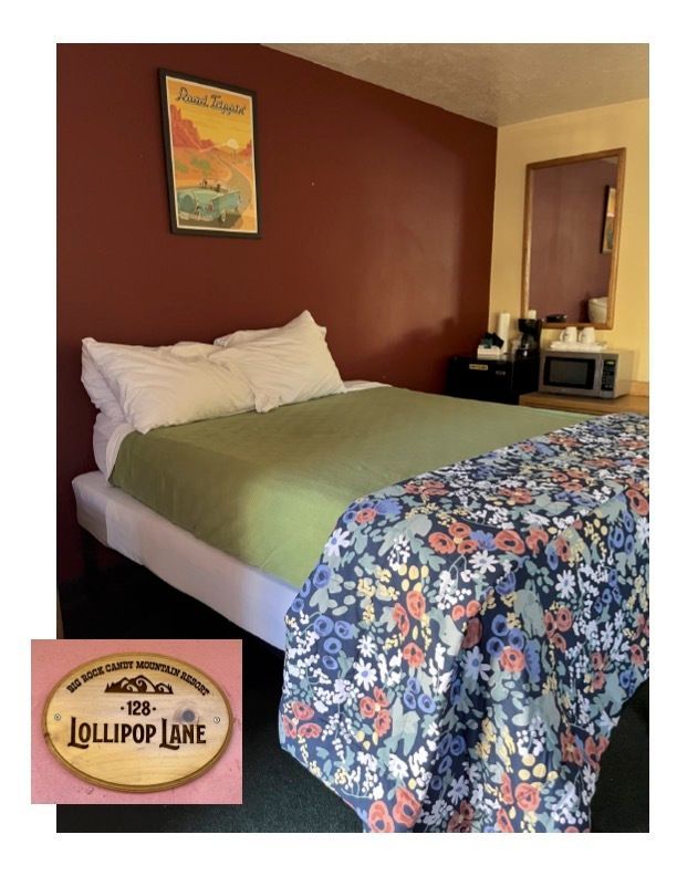 A hotel room with a bed and a sign that says lollipop lane