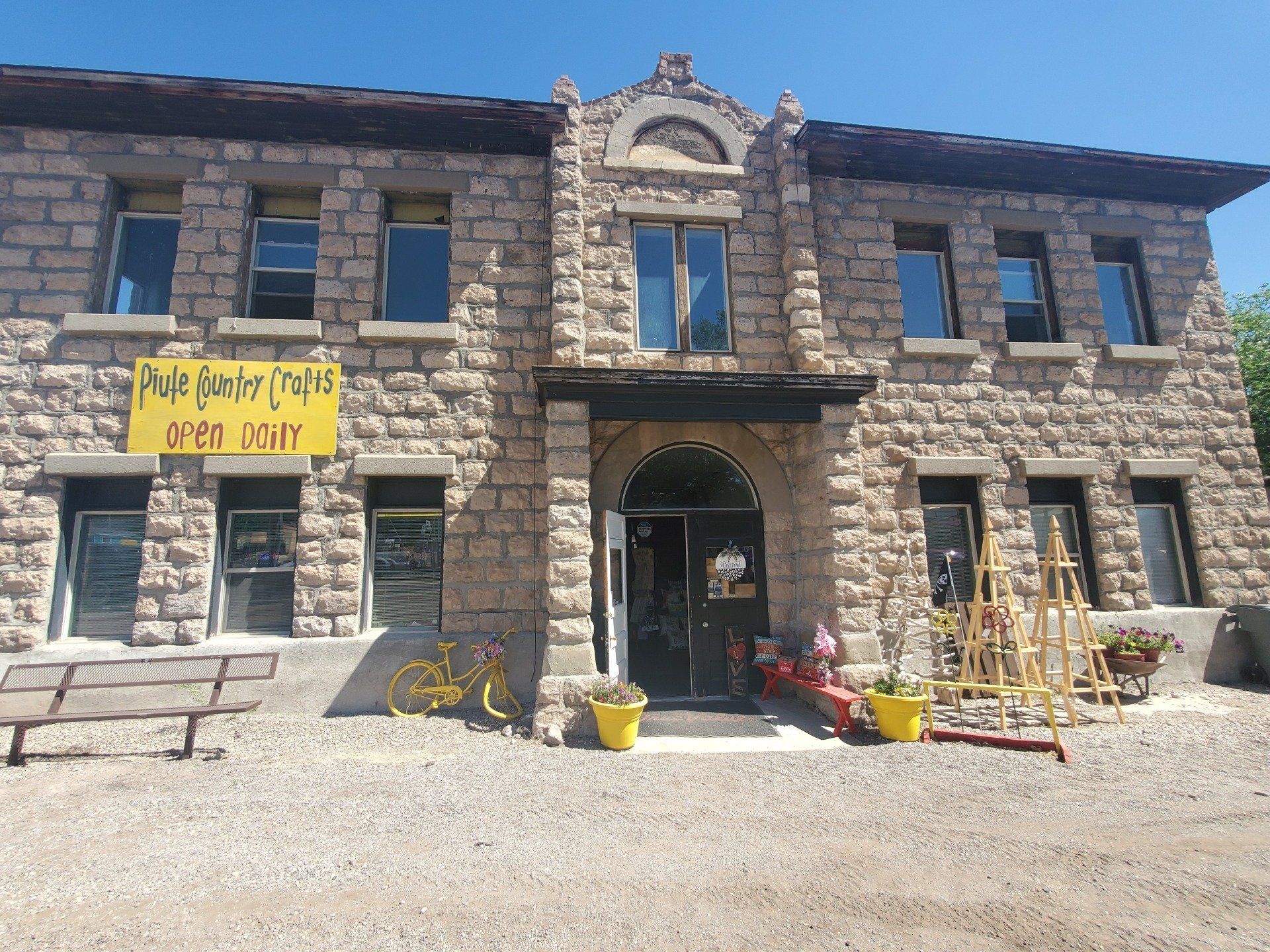 A large brick building with a yellow sign that says ' pueblo ranch crafts ' on it