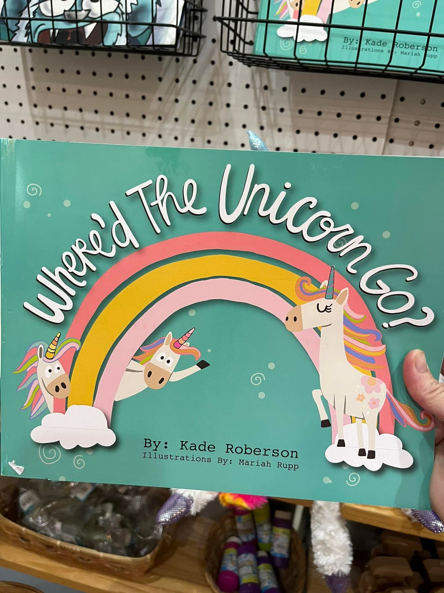 A person is holding a book titled where the unicorns go