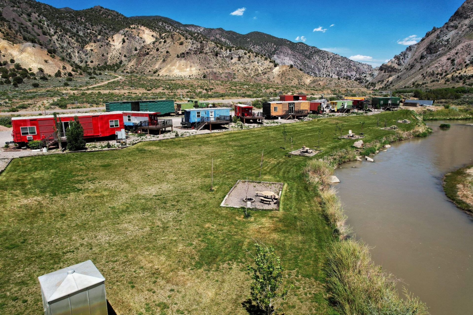 An aerial view of a row of trailers parked next to a river.