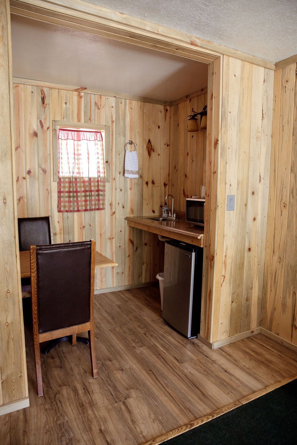 A kitchen with a table and chairs and a refrigerator