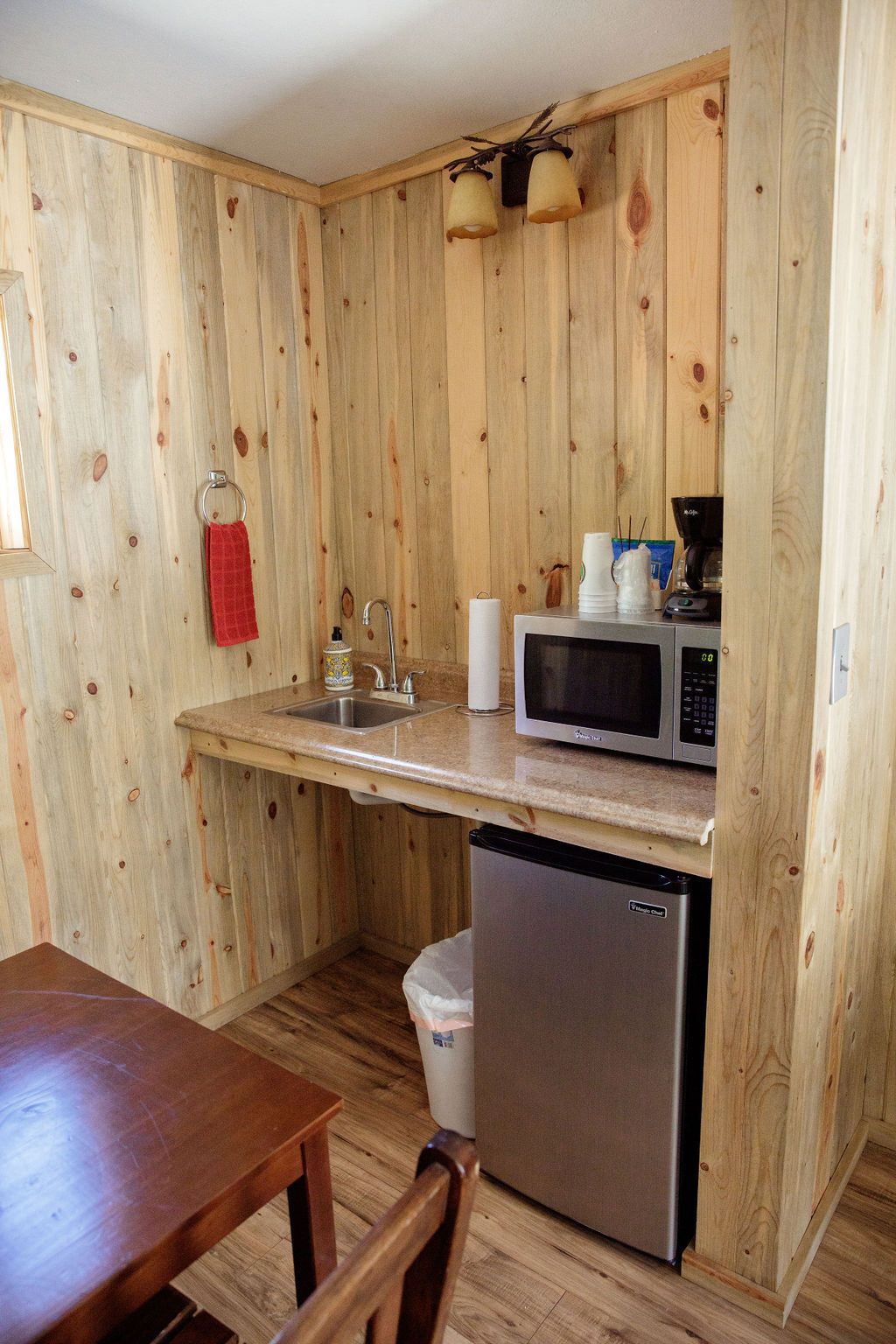 A kitchen with a sink , microwave , and refrigerator