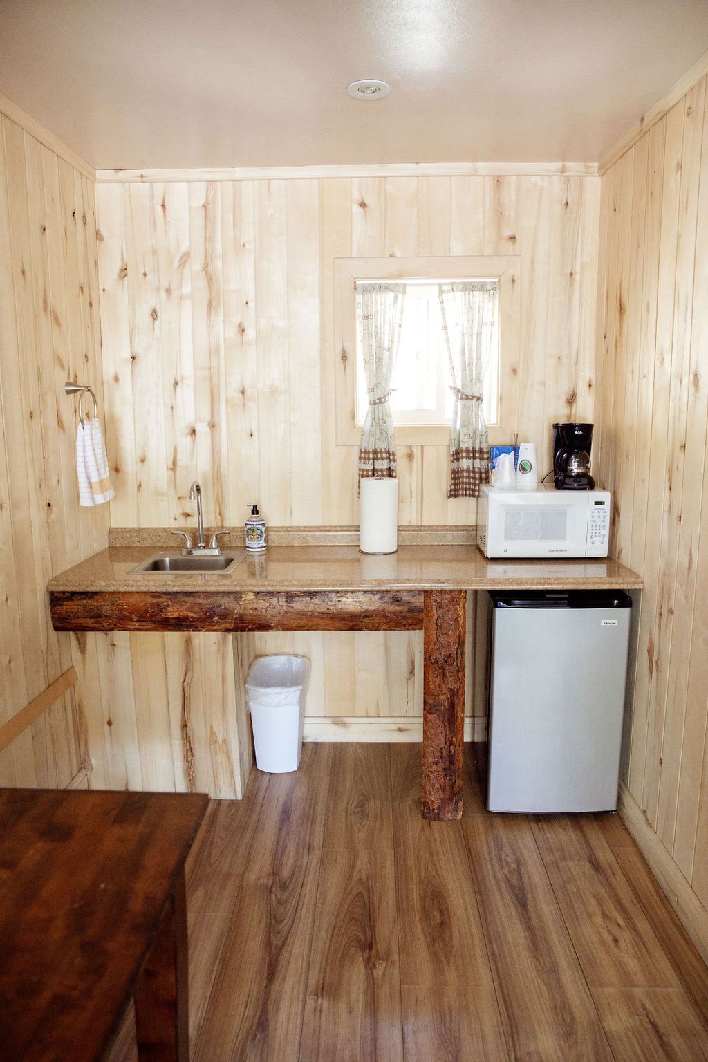 A small kitchen with a sink , microwave , and refrigerator.