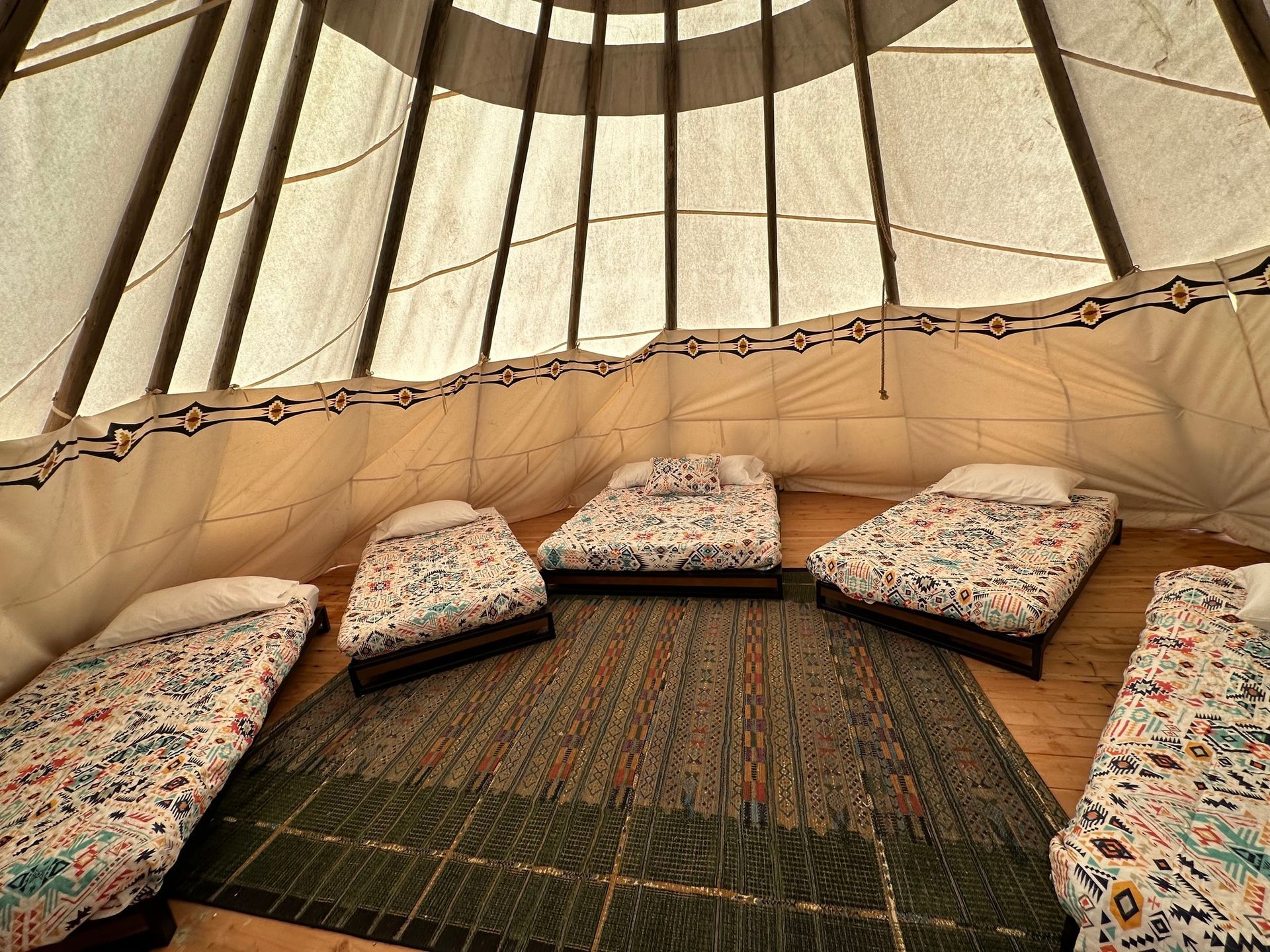 A group of beds are lined up in a teepee.