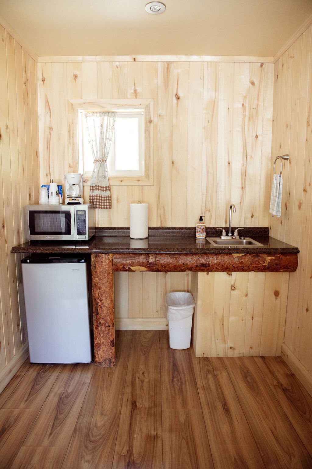 A small kitchen with a sink , microwave , and refrigerator.