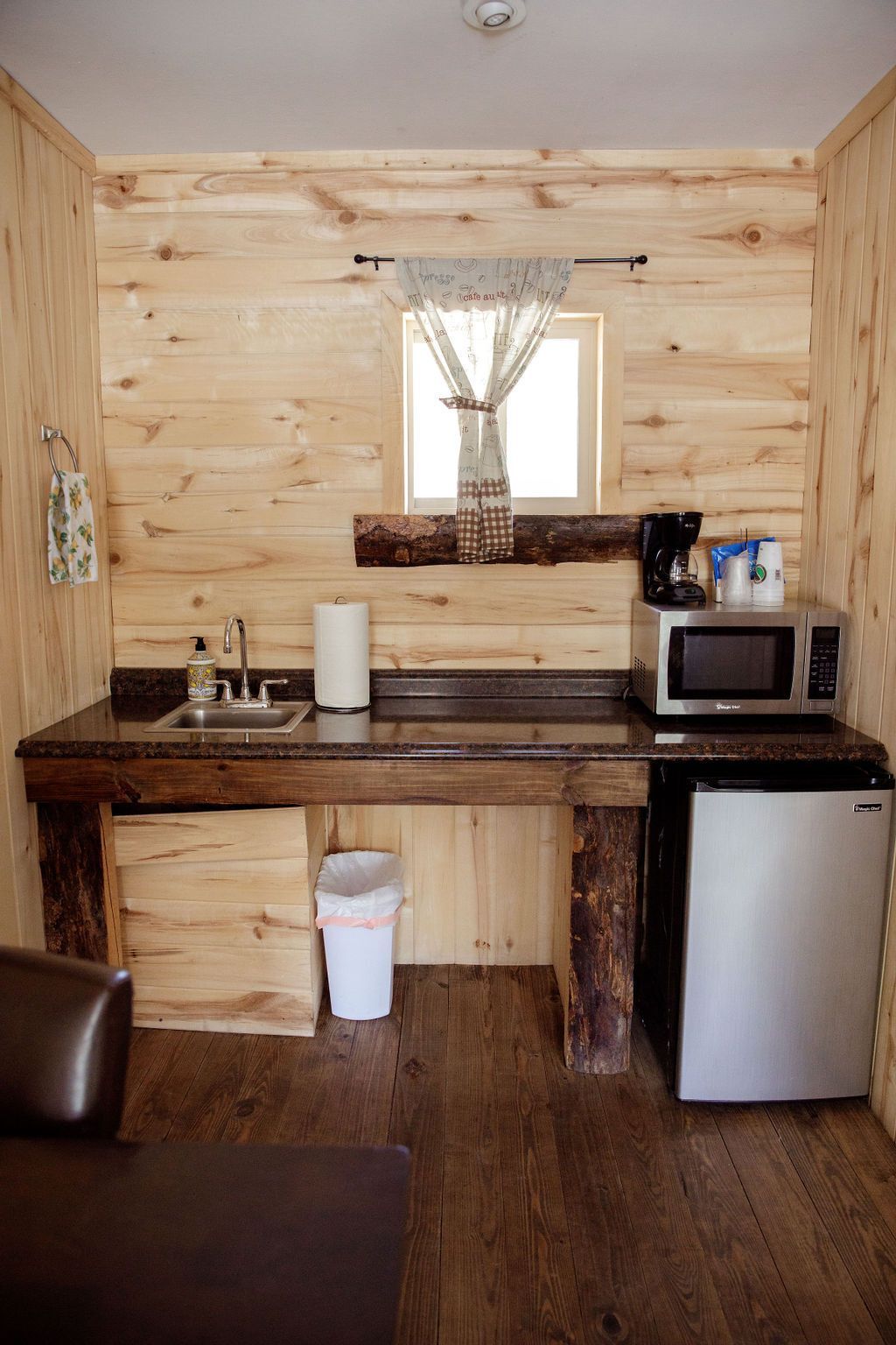 A small kitchen with a sink , microwave , and refrigerator.