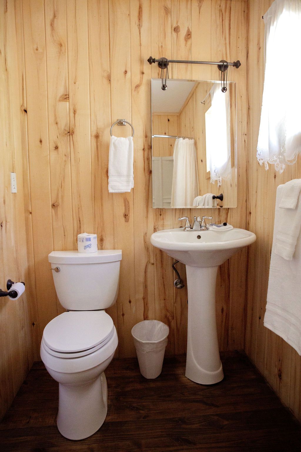 A bathroom with a toilet a sink and a mirror