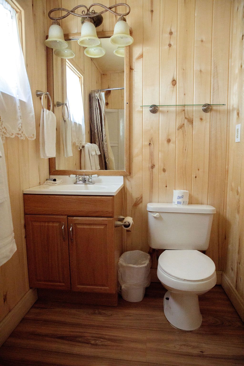 A bathroom with a sink , toilet and mirror.