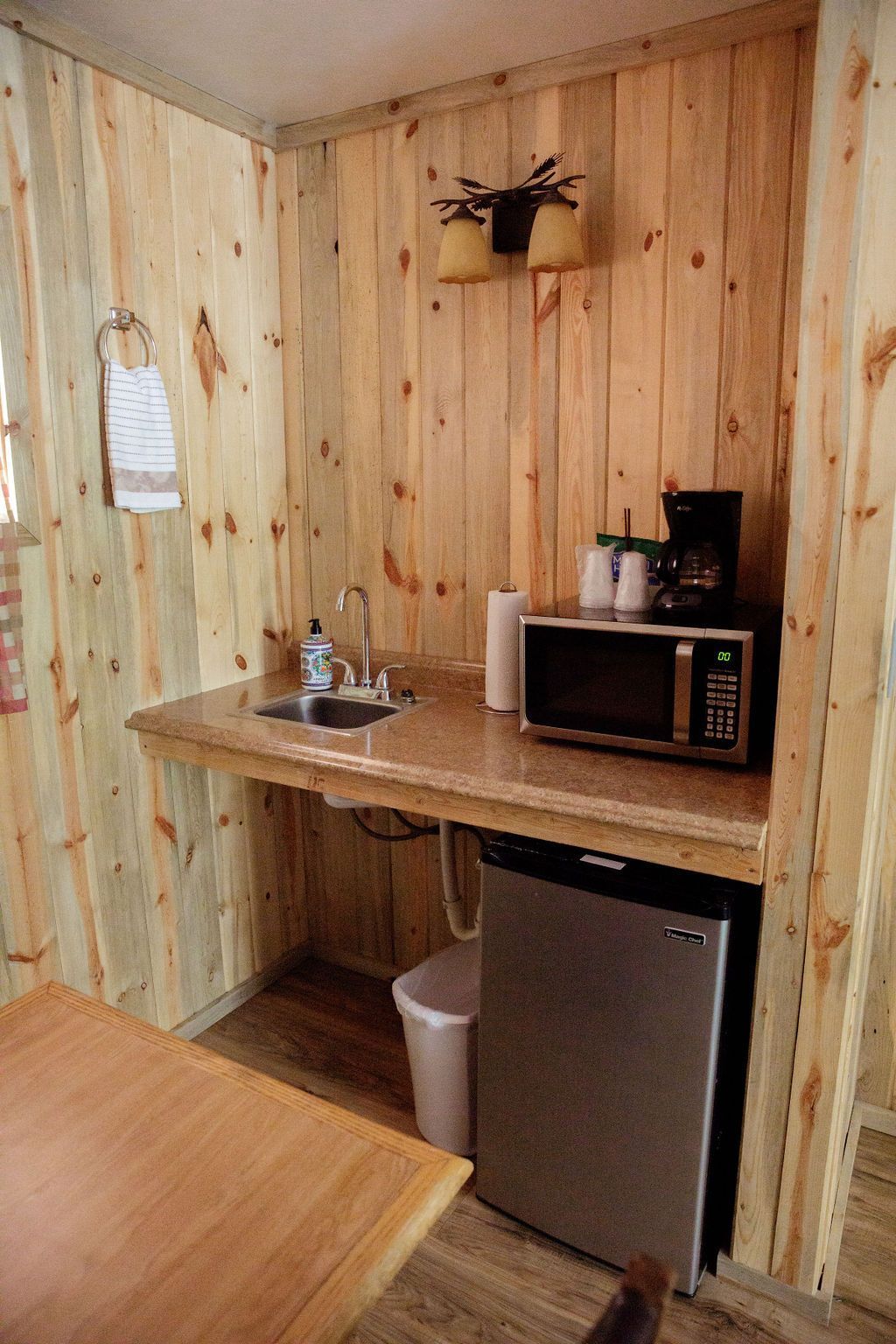 A small kitchen with a sink , microwave and refrigerator